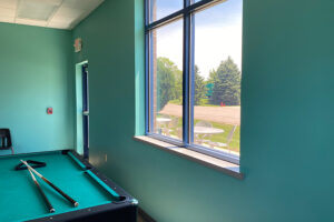 Student lounge pool table and window looking out to green space.