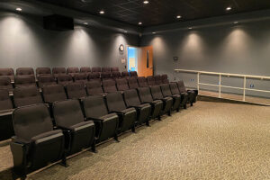 Small theater with rows of chairs and dimmed lighting.